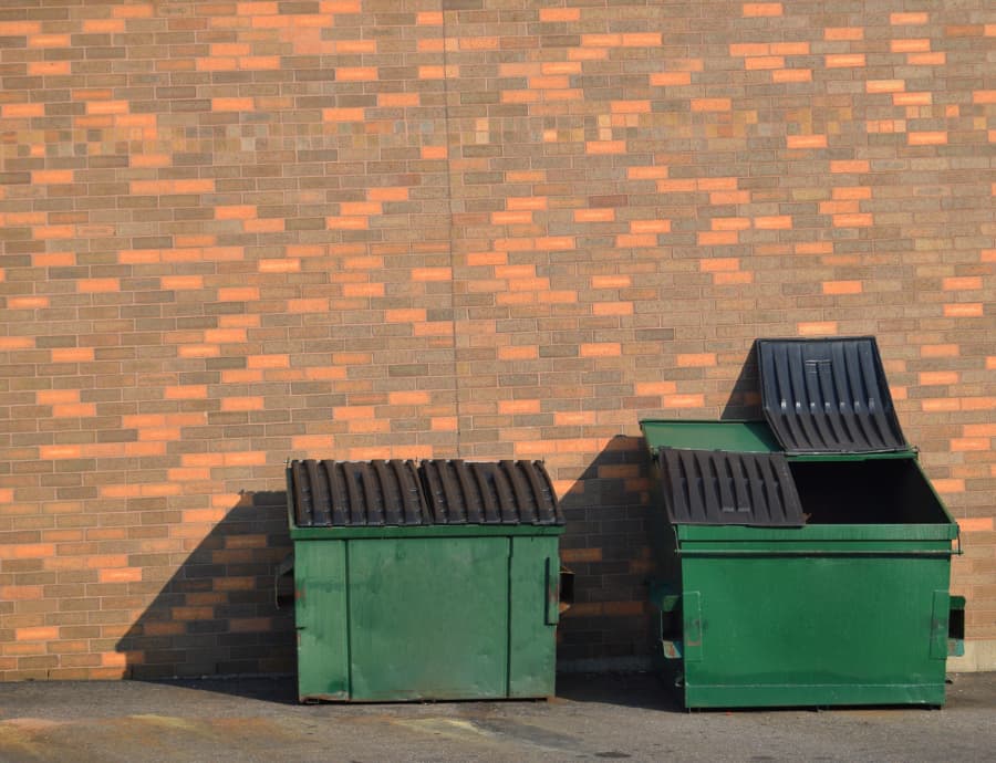 Green front end loader dumpsters side by side