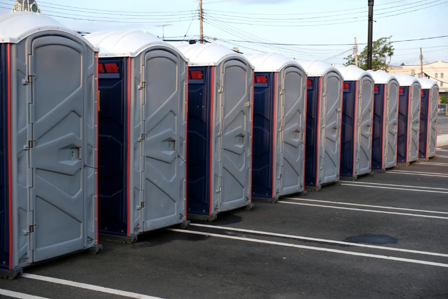 Row of portable toilets in parking lot